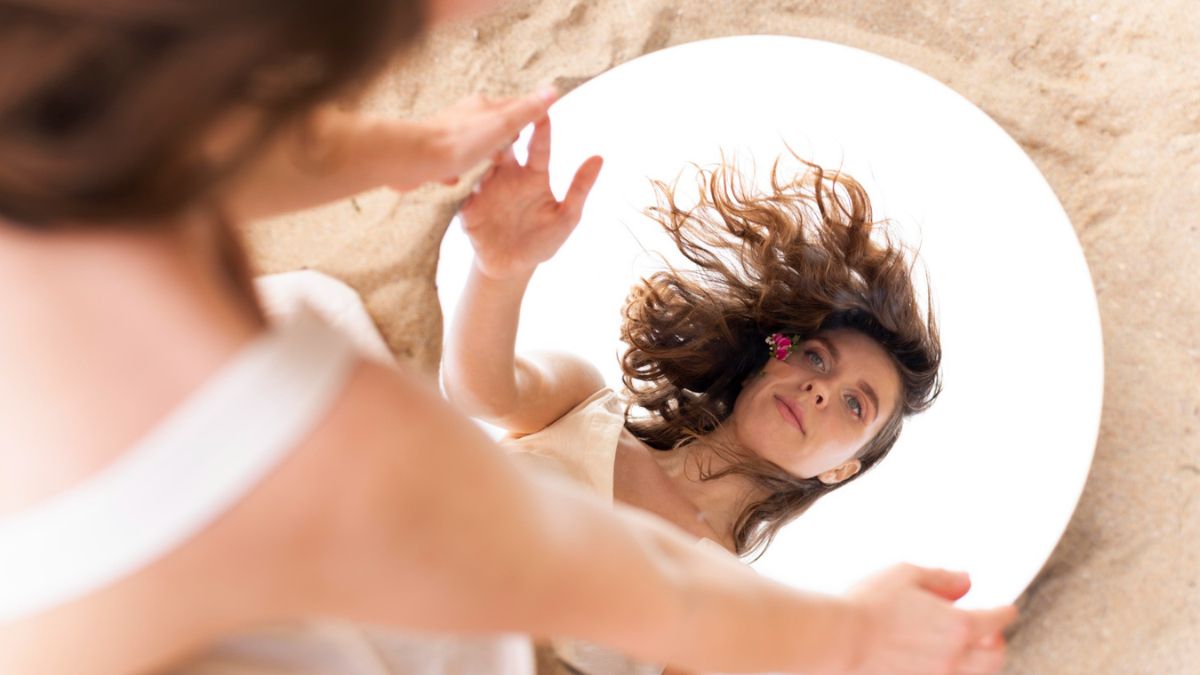 Mulher em momento de pausa tranquila, simbolizando o autocuidado feminino e a reconexão interior