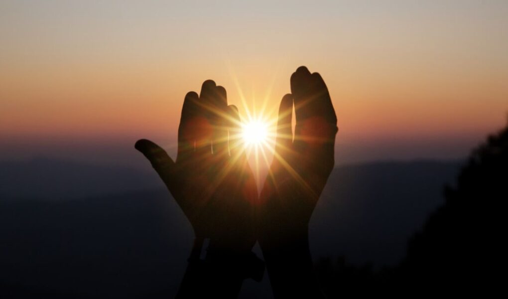Mãos buscando a luz e a vivência de uma espiritualidade sem religião