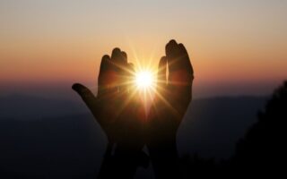 Mãos buscando a luz e a vivência de uma espiritualidade sem religião