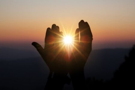 Mãos buscando a luz e a vivência de uma espiritualidade sem religião
