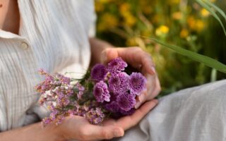 mulher segurando flores para representar o uso dos florais