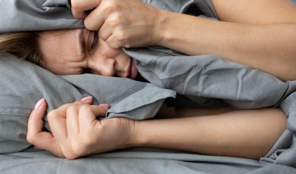 Mulher com dificuldade para dormir tomando florais para insonia