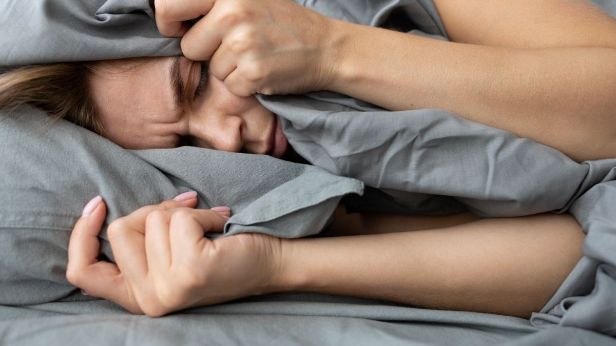 Mulher com dificuldade para dormir tomando florais para insonia